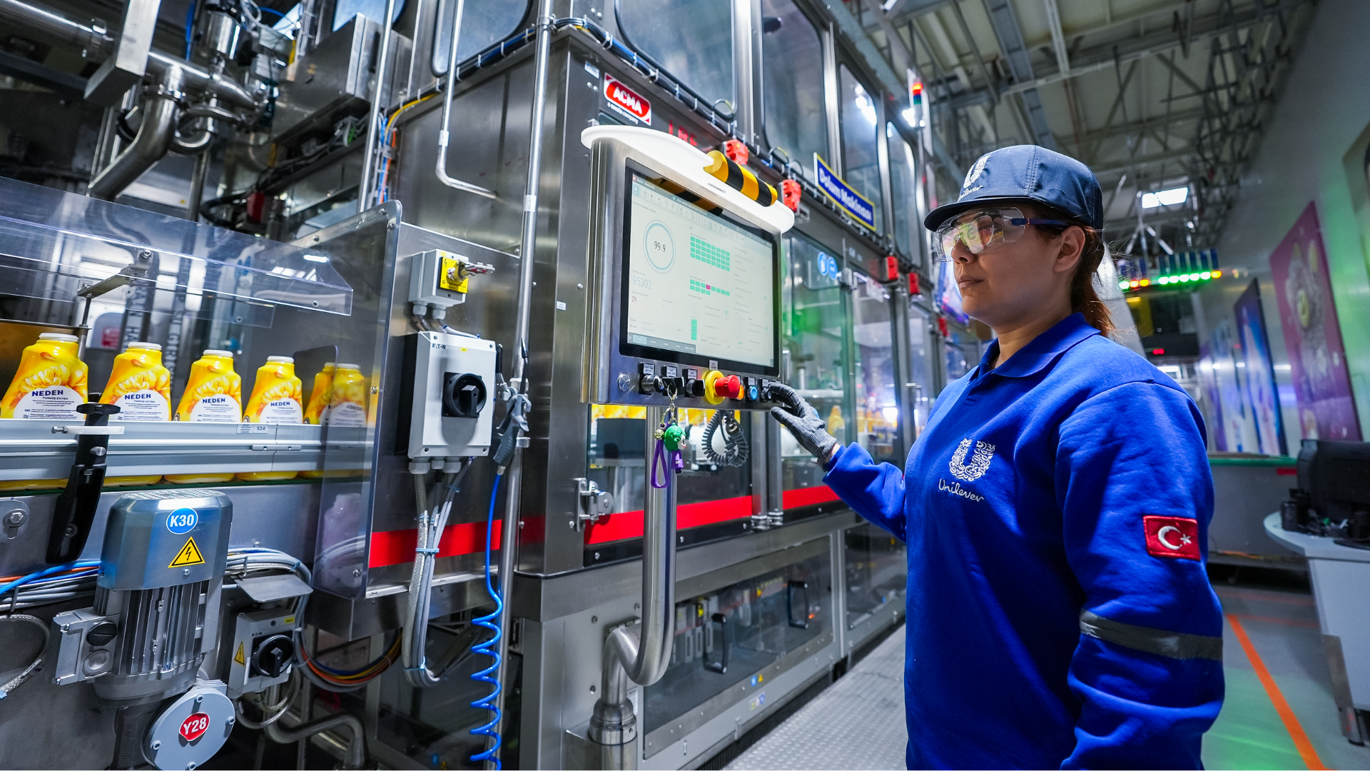 Kadın fabrika çalışanı üretim hattı önünde.