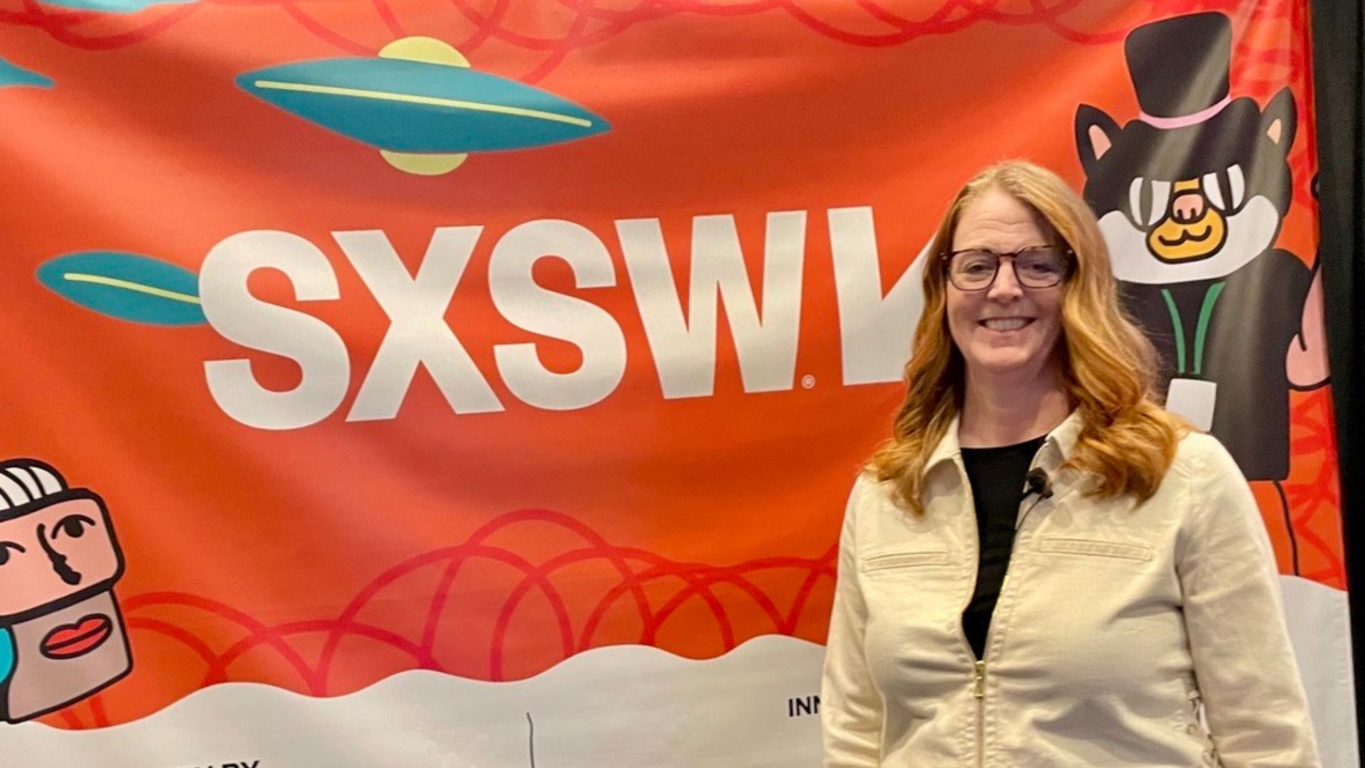 Unilever Kişisel Bakım Bölümü Bilim ve Teknoloji Kıdemli Başkan Yardımcısı Dr. Samantha Samaras, parlak bir SXSW konferans afişinin önünde gülümseyerek poz veriyor.