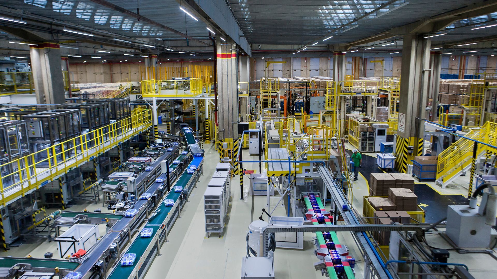 Konveyör bantları üzerinde ürünler bulunan bir fabrika üretim hattının görünümü.