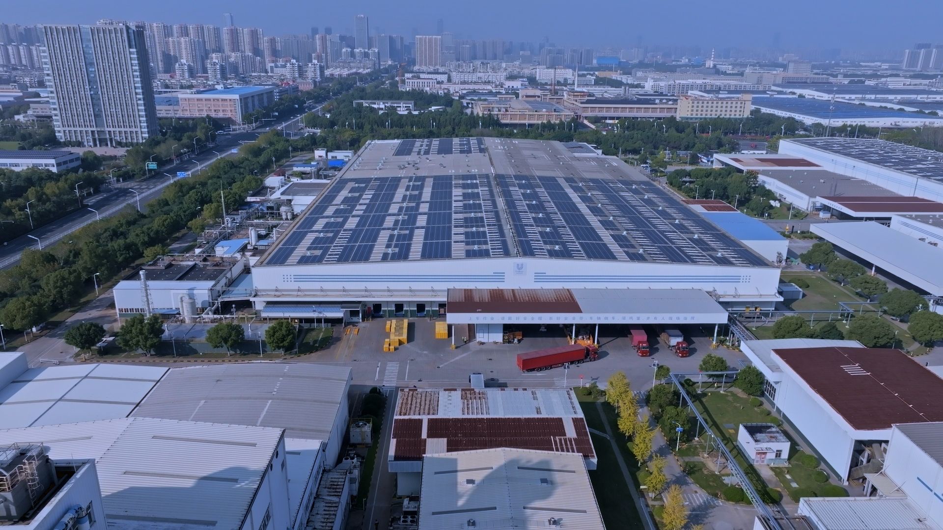 Çin'deki Unilever'in Hefei fabrikasının, çatısında güneş panelleri bulunan bir görüntüsü. Arka planda şehir görünüyor.